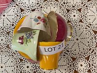 Photo of the stacked set of four cups showing colorful floral designs and lot number label.
