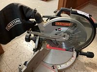 Front and side view showing dust collection bag and blade guard with Craftsman branding.