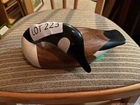 Front and side profile of the hand carved wooden duck decoy showing its painted head and body with a natural wood finish.