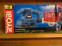Box of Ryobi 1/3 sheet sander showing branding, model info and 2.0 amp power rating