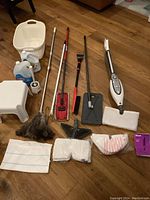 Wide view of lot showing majority of items including bucket, stool, sprays, various brooms, duster, mop and mop accessories