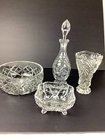 4-piece vintage crystal set showing decanter, square footed dish, round bowl, and vase with detailed cuts and patterns