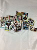 Overview of a large pile of vintage 1980s MLB and NHL sports cards assorted loosely on a surface.