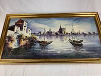 Frontal view of entire framed painting showing ocean scene, two boats, and coastal buildings under cloudy sky.