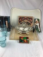 Full lot showing Pyrex dish, wood board with native art, plastic serving tray, plastic glasses, water bottles, and wood boxes