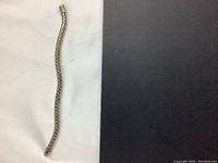 Full view of the silver snake chain bracelet laid out showing its length and weave pattern.