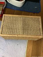 Top view of wicker trunk showing woven wicker lid and wooden frame