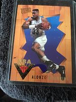 Single Fleer Ultra Alonzo Mourning basketball card with orange background and blue starburst design.