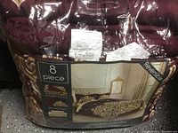 Photos of the sealed king size 8-piece comforter bed ensemble package showing reversible pattern design and set details.
