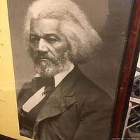 Close-up of the black and white photographic portrait of Frederick Douglass on the poster.