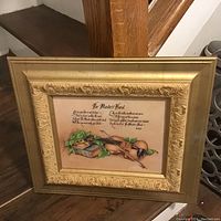Photo of one framed home decor print titled "The Master's Hand" showing a violin, books, ivy leaves, and a poem in a gold ornate frame placed near stairs.