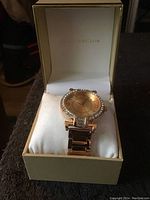 Angle of watch inside box showing overall style, band, dial, and crystal decoration.