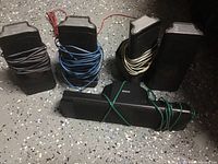 Five RCA speakers displayed, four tall rectangular and one horizontal center speaker, each with distinct attached colored wires.