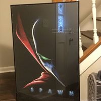 Framed Spawn movie poster showing close-up mask and cape with text 'Born in Darkness Sworn to Justice' and 'SPAWN'.