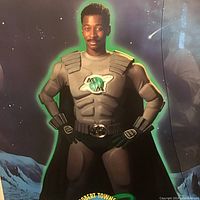 Full view of the superhero figure in costume from The Meteor Man poster with starry night background and mountains in the distance.