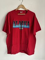 Front view of red XL Harley-Davidson T-shirt with 'ALASKA' and Harley-Davidson logo print.