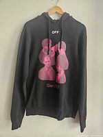 Front view of black hoodie with pink graphic of heads and OFF text, Tour '13 text below graphic