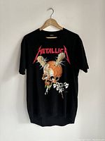 Front view of the Metallica black t-shirt with skull and spikes graphic, band name and text.