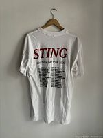 Rear view of white T-shirt with red "STING" text and black printed tour dates for Brand New Day Tour 2000.