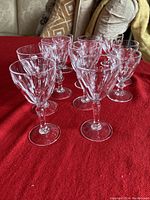 5 larger sherry glasses arranged on red cloth showing the cut crystal design and shape