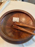 Top view of the wooden salad bowl with two matching wooden salad servers inside showing the wood grain and smooth finish.