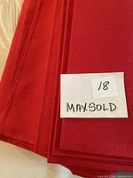 Photo of the fabric folded with a handwritten note '18 Maxsold' placed on top indicating lot number or tag.