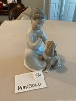 Full view of the Lladro figurine showing the boy sitting with dog.