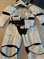 Full Stormtrooper outfit laid flat showing jacket and pants with padding and black trim.