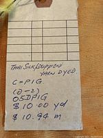 Close-up of tag stating 'Thai Silk/Duppioni Yarn Dyed' with price per yard and meter.