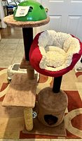 Photo of the entire cat tree showing the base cubby, scratching post, red and white plush bed, upper platform with green dome toy.