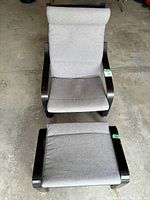 Top-down view of gray upholstered chair with matching ottoman showing cushions and curved wooden frames.