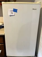 Front exterior of white Magic Chef bar fridge showing door closed.