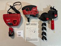 Group shot of palm nailer, charger, battery pack, operator’s manual, four collet attachments and Bessey clamp.