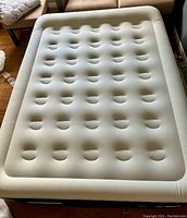 Top view of inflated beige and blue queen air mattress with distinct air pockets