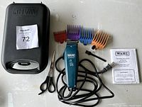 Overview of the Wahl pet shaver lot contents including the clipper, comb attachments, scissors, cleaning brush, oil bottle, instruction booklet and carrying case.