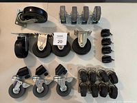 All castered and fixed wheels laid out on white surface.