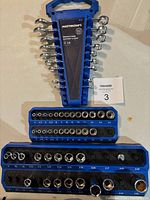 Top view showing 9 metric combination wrenches arranged in blue Mastercraft wrench rack; size markings visible from 7 to 18 mm.