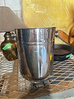 Front and side view of stainless steel wine/ice bucket showing reflective surface and side handles