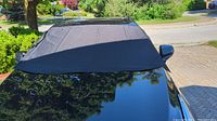 Black windshield cover installed on car windshield, protects the windshield and wipers.