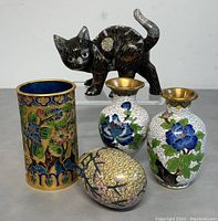 Front view of all five items showing the cloisonné vases, cat figurine, egg-shaped box, and cylinder shaped container