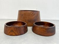 Front view of the three wooden bowls arranged with the large bowl behind the two smaller ones, showing the varying shapes and rich wood grain.