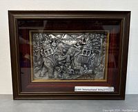Frontal view of the framed 3D metal wall art depicting an elephant with riders in an Asian scene, showing the full artwork and wood frame.