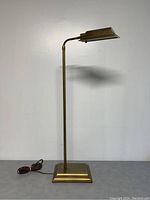 Front view of vintage brass short floor lamp showing entire lamp with square brass base and rectangular brass shade.
