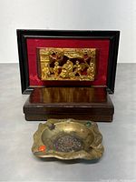 Vintage Chinese wall hanging sculpture and vintage brass ashtray displayed together