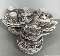 Overall front and angled side view of over 40-piece dish set including stacked plates, cups, and serving pieces