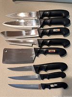 Top-down view of all 8 knives laid out, showing blade types and black handles