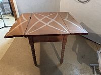 Table with both leaves extended showing enamel top with decorative geometric pattern