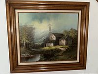 Framed vintage oil painting showing the entire artwork and frame, highlighting the rustic landscape scene and signature in the lower right corner.