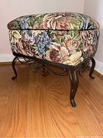 Side angle view highlighting tapestry fabric upholstery and metal scroll legs.