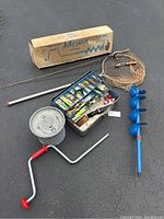 Full lot: Mora ice auger in box, fishing poles, net, tackle box with lures, bait bucket, ice auger handle